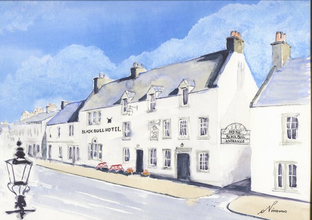 The long white Black Bull Hotel on Lauder's main street, with dormer windows, the hotel lettering and entrance sign, red picnic tables and a street lamp in the foreground, under a blue sky.