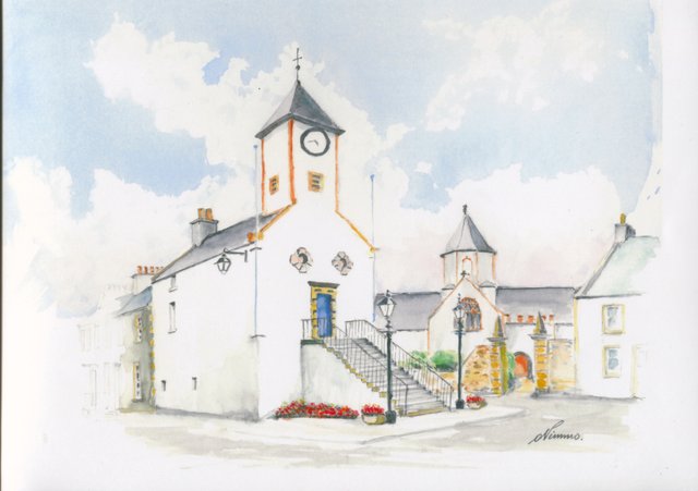 Lauder's white town hall with its clock tower and outside stair, the church tower behind, street lamps and planters of red flowers.